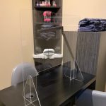 - Spa Bleü in West Dundee, St. Charles and South Barrington, IL A manicure station with a clear acrylic divider, chair, towels, nail polish bottles, and a small sink in the background—perfect for relaxing before enjoying the best facial or picking up salon gift cards. - Spa Bleü in West Dundee, St. Charles and South Barrington, IL