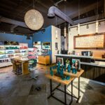 - Spa Bleü in West Dundee, St. Charles and South Barrington, IL Modern Aveda Salon interior with product displays, a reception counter, shelves stocked with Aveda Color and beauty products, pendant lighting, and a large decorative chandelier—perfect for a relaxing day spa experience. - Spa Bleü in West Dundee, St. Charles and South Barrington, IL