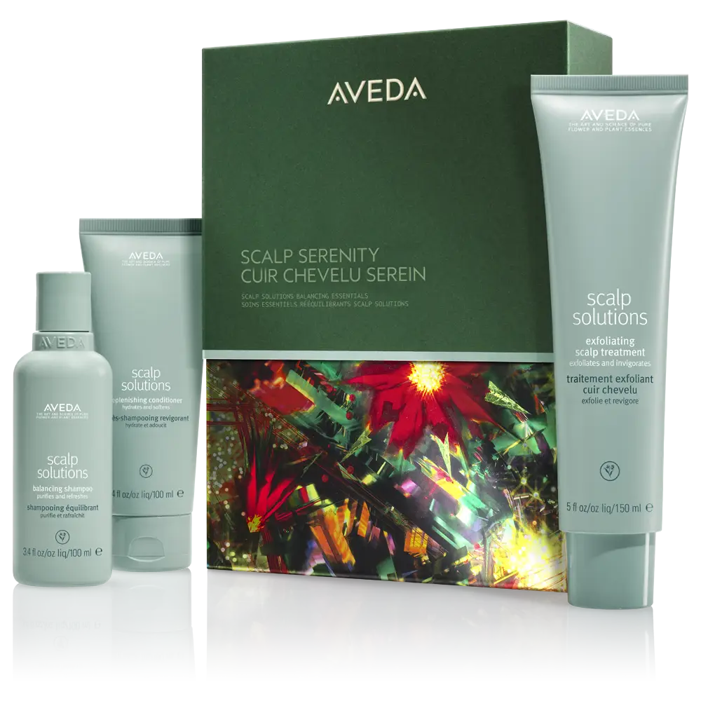Aveda Scalp Solutions set includes three hair care products in light green packaging, displayed before a decorative box with colorful floral artwork—perfect for inspiring festive hair ideas and seasonal hairstyles. - Spa Bleü in West Dundee, St. Charles and South Barrington, IL