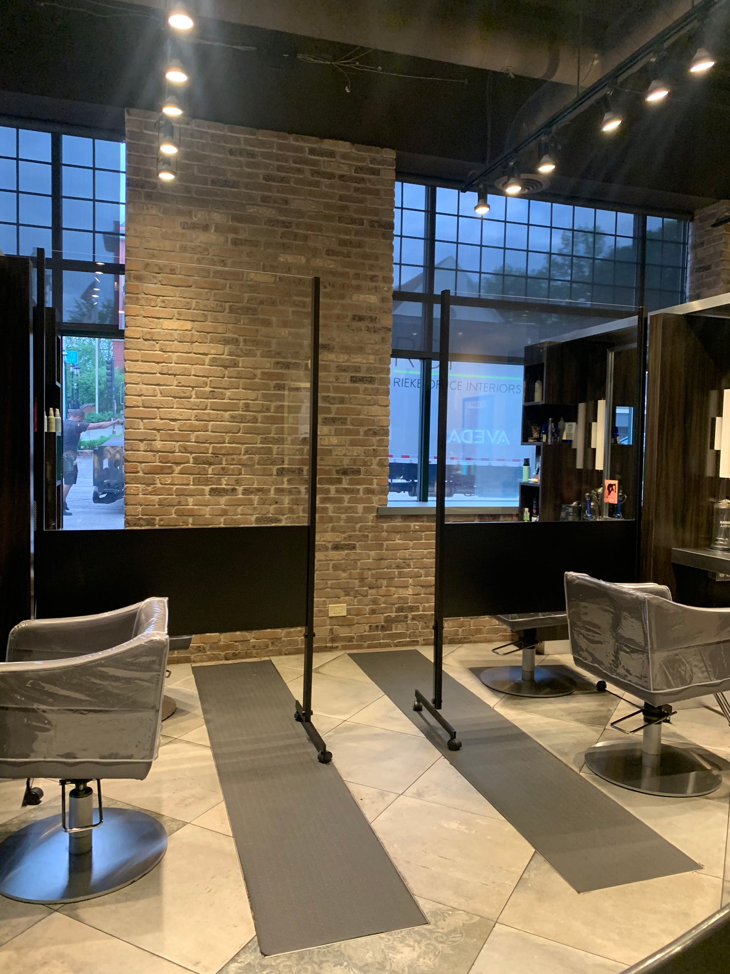 - Spa Bleü in West Dundee, St. Charles and South Barrington, IL A modern Aveda Salon interior with two styling chairs, protective plastic barriers, large windows, brick walls, and overhead track lighting—perfect for a fresh cut or to purchase Salon Gift Cards. - Spa Bleü in West Dundee, St. Charles and South Barrington, IL